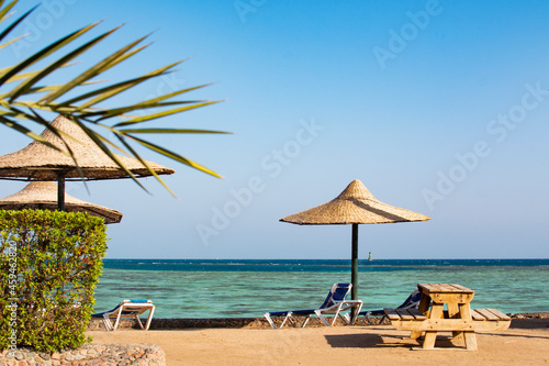 View of the beach with umbrellas and palm trees, the red sea, Hurghada, Egypt photo