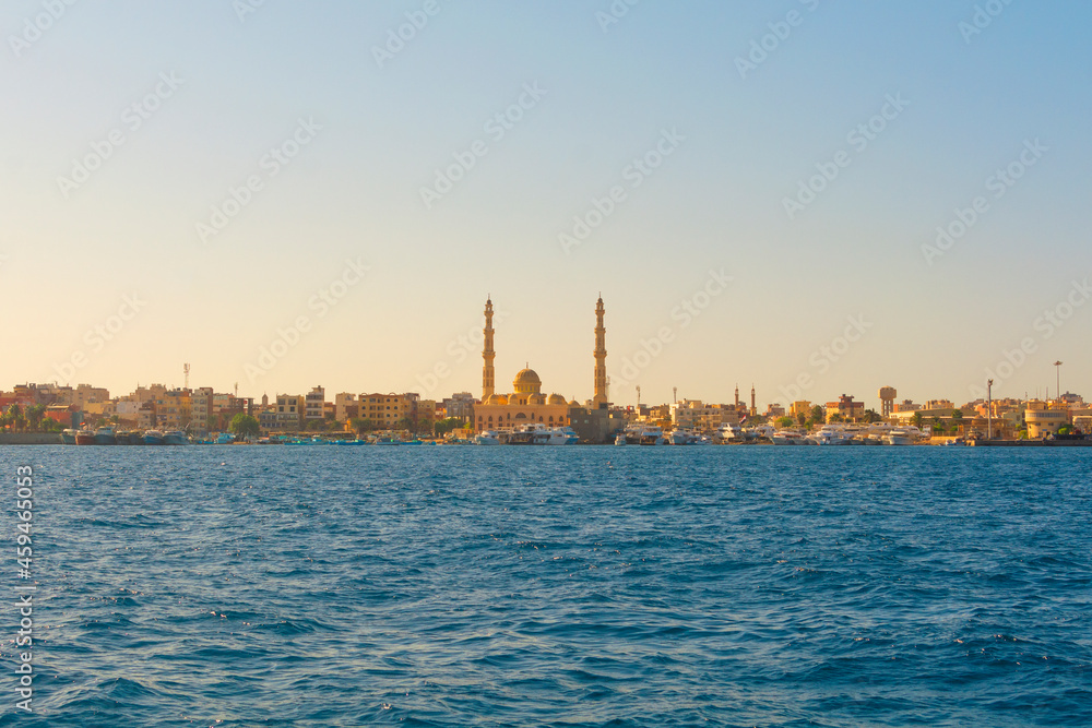 HURGHADA, EGYPT - September 22, 2021 : Mosque El Mina Masjid and the marina with the ships in Hurghada in sunny day, view from the sea.