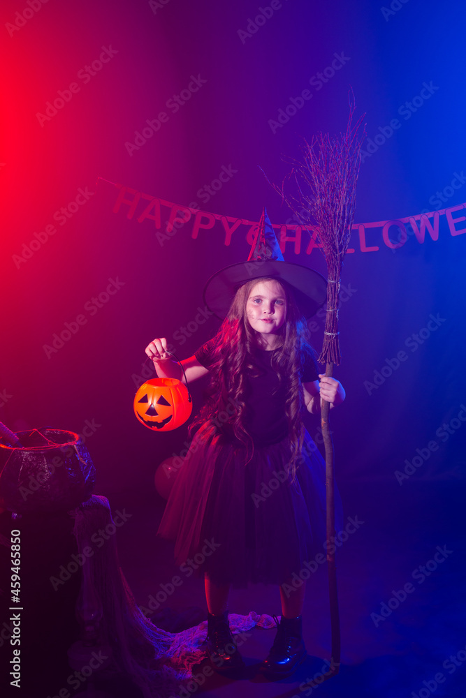 Little girl holds broom on Halloween holiday. Kid girl wear witch costume. Fantasy, fairy tale and masquerade concept. Little girl holds broom on Halloween holiday. Kid girl wear witch costume. Fantasy, fairy tale and masquerade concept.