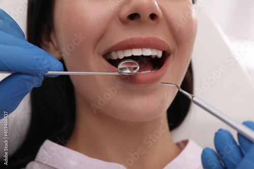 Dentist examining young woman s teeth  closeup view