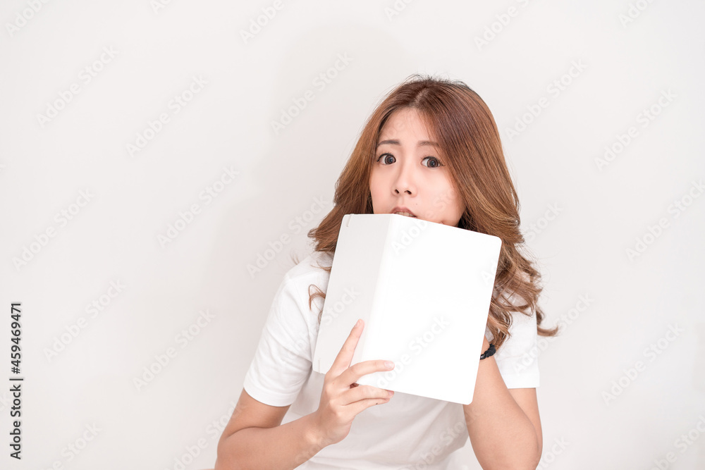 Young attractive asian student holding books in her arm on white background. School girl with a books to read for homework. Young attractive asian student holding books in her arm on white background. School girl with a books to read for homework.