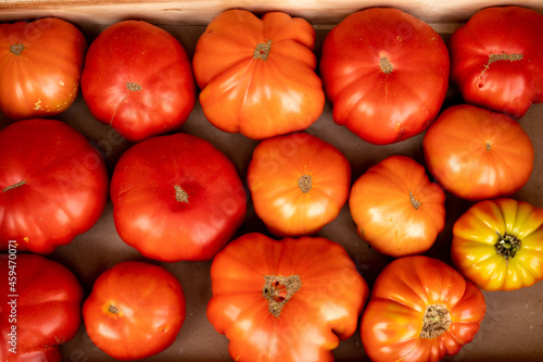 Tasty big ripe french tomatoes in wooden boxes on farmers market in Provence