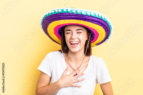 young hispanic woman laughing out loud at some hilarious joke. mexican hat concept