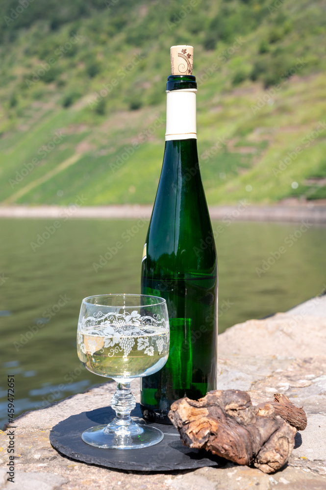 Tasting of white quality riesling wine with view on steep slopes of vineyards overlooking Mosel river in sunny day Tasting of white quality riesling wine with view on steep slopes of vineyards overlooking Mosel river in sunny day