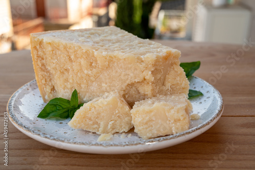 Cheese collection, piece of matured cow cheese pasmesan parmigiano reggiano and Italian houses on background photo