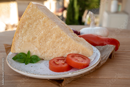 Cheese collection, piece of matured cow cheese pasmesan parmigiano reggiano and Italian houses on background photo