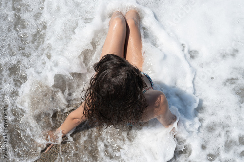 Young woman in a wave from the sea