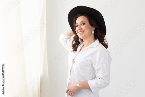 Portrait of a beautiful graceful woman in elegant hat with a wide brim and copyspace advertisement. Beauty and fashion concept.
