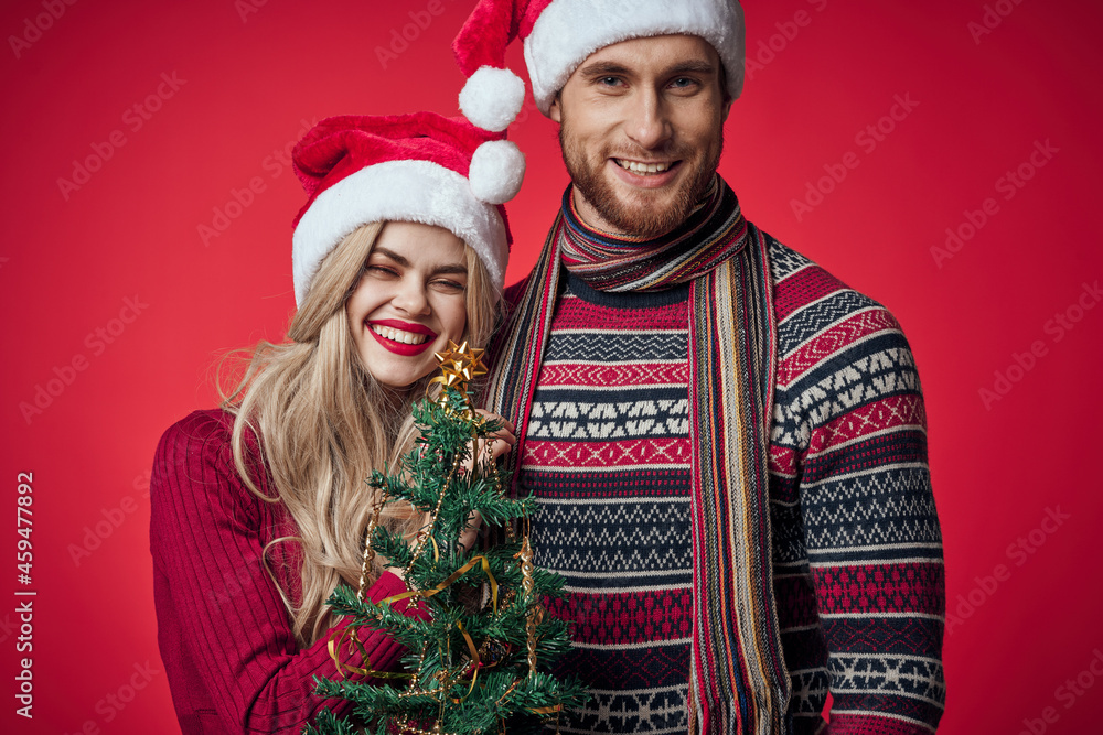 cute young couple holding christmas tree toys decoration red background cute young couple holding christmas tree toys decoration red background