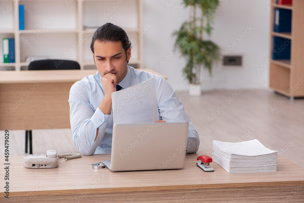 Young male employee working in the office Young male employee working in the office
