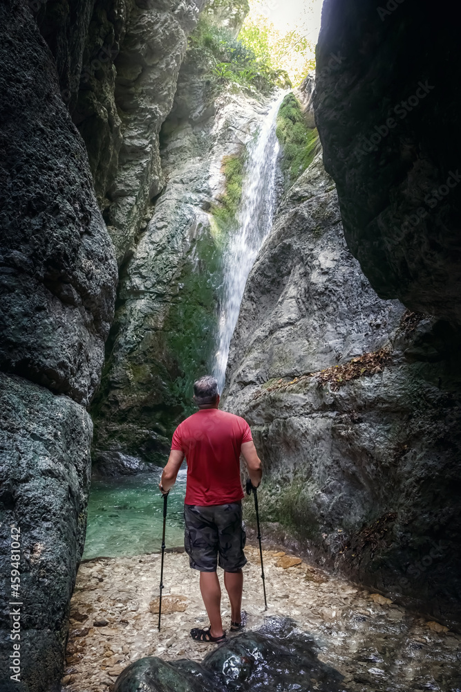 Hiker in the gorge with the waterfall