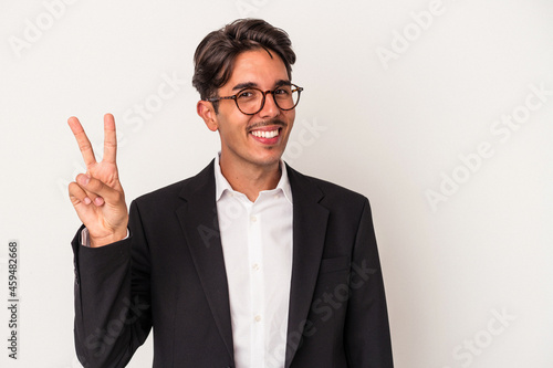Young mixed race business man isolated on white background joyful and carefree showing a peace symbol with fingers.
