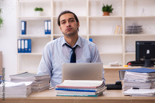 Young male employee and too much work in the office