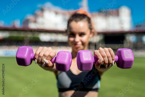  Fitness trainer doing stretching workout with dumbbells