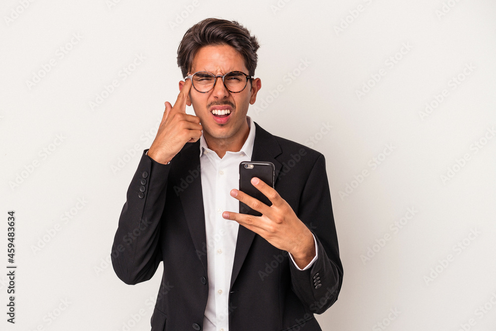 Young mixed race business man holding mobile phone isolated on white background showing a disappointment gesture with forefinger. Young mixed race business man holding mobile phone isolated on white background showing a disappointment gesture with forefinger.