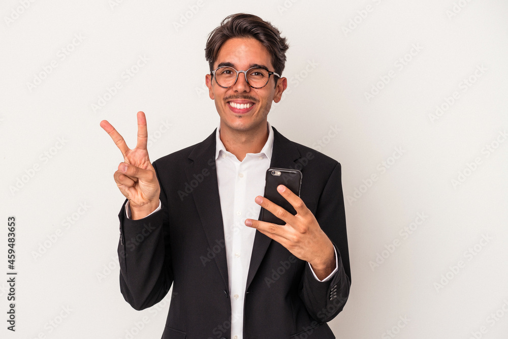 Young mixed race business man holding mobile phone isolated on white background showing number two with fingers. Young mixed race business man holding mobile phone isolated on white background showing number two with fingers.