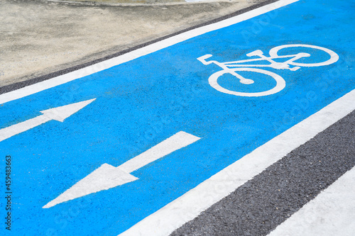 Blue bicycle lane on road with white bicycle icon and arrow. Empty Bicycle way for bike.