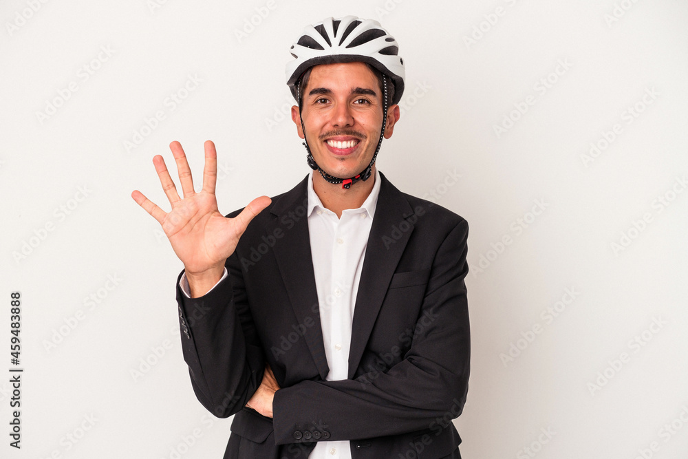 Young mixed race business man wearing a bike helmet isolated on white background smiling cheerful showing number five with fingers. Young mixed race business man wearing a bike helmet isolated on white background smiling cheerful showing number five with fingers.