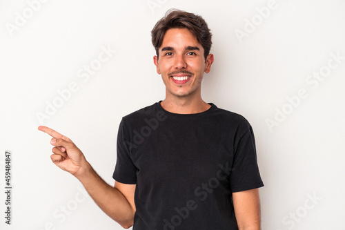 Young mixed race man isolated on white background smiling cheerfully pointing with forefinger away.