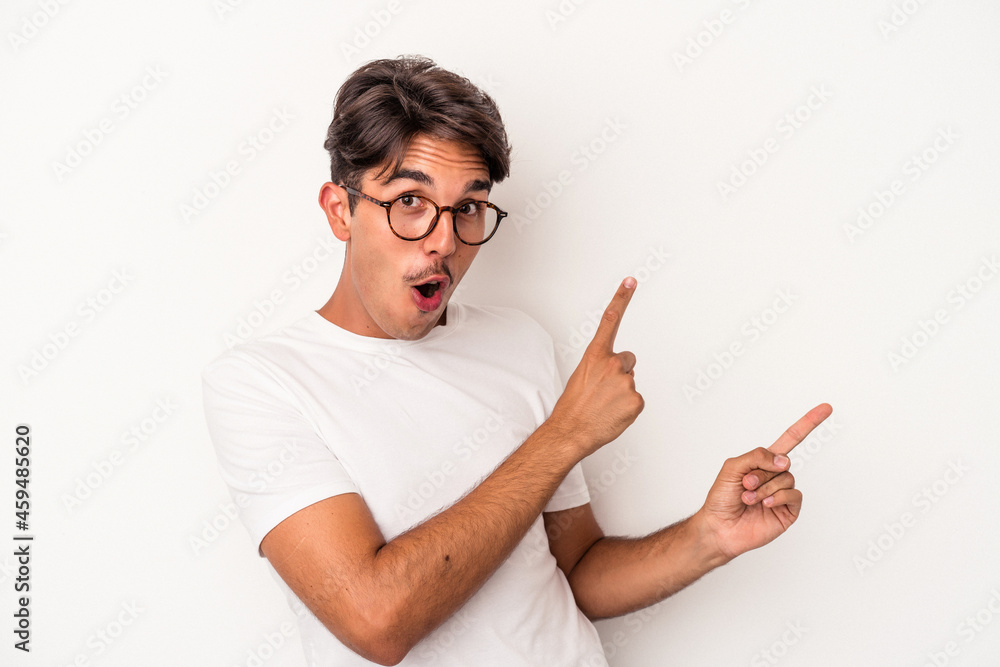 Young mixed race man isolated on white background pointing with forefingers to a copy space, expressing excitement and desire. Young mixed race man isolated on white background pointing with forefingers to a copy space, expressing excitement and desire.