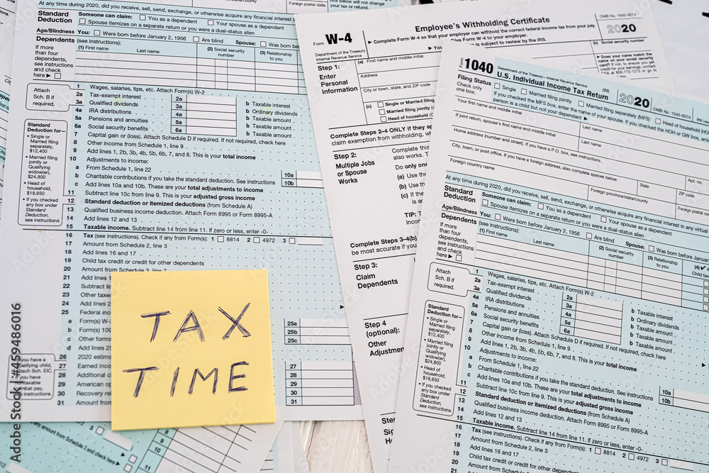 Obraz premium many American tax forms 1040 lie mixed with a piece of paper from a notebook on them