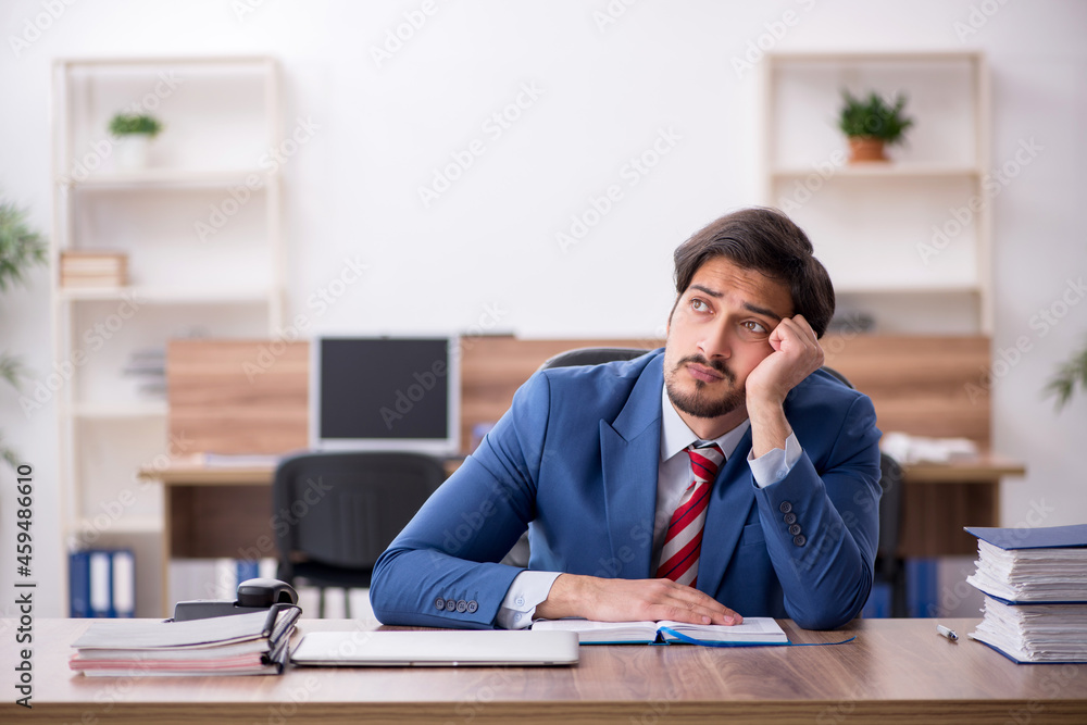 Young male employee sitting at workplace Young male employee sitting at workplace