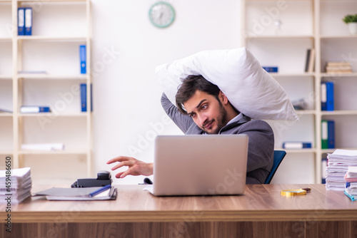 Young male employee in oversleeping concept