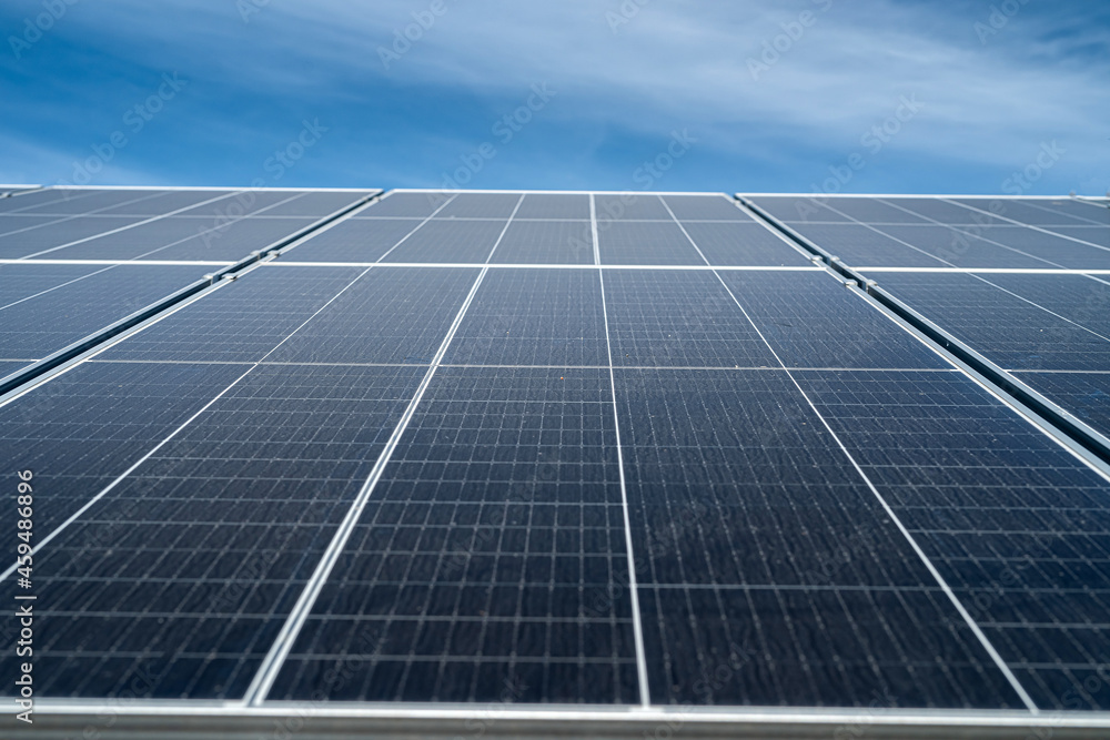 against the background of a beautiful blue sky new clean energy saving solar panels stand. against the background of a beautiful blue sky new clean energy saving solar panels stand.