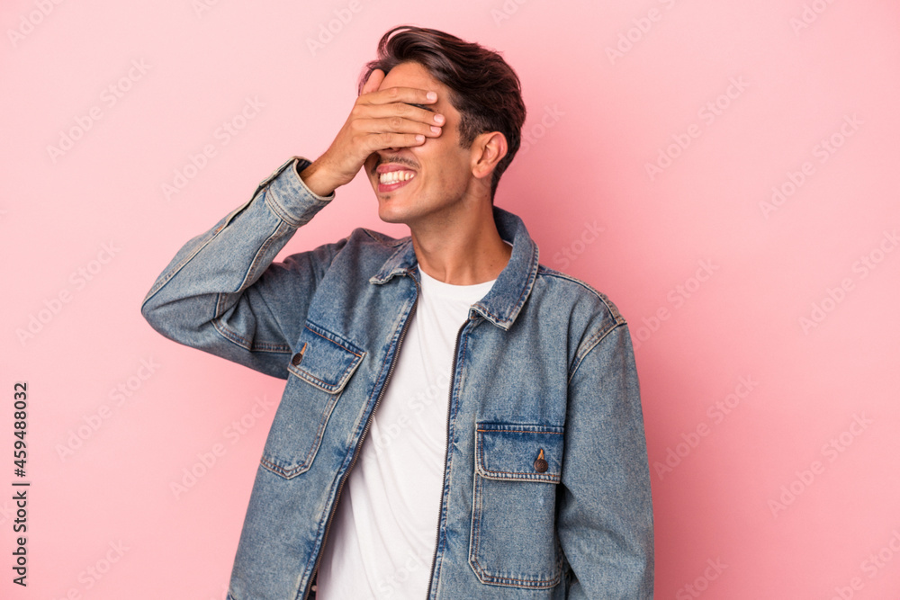 Young mixed race man isolated on white background covers eyes with hands, smiles broadly waiting for a surprise. Young mixed race man isolated on white background covers eyes with hands, smiles broadly waiting for a surprise.