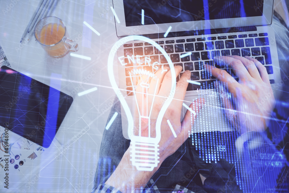 Double exposure of man's hands typing over computer keyboard and bulb hologram drawing. Top view. Idea concept. Double exposure of man's hands typing over computer keyboard and bulb hologram drawing. Top view. Idea concept.