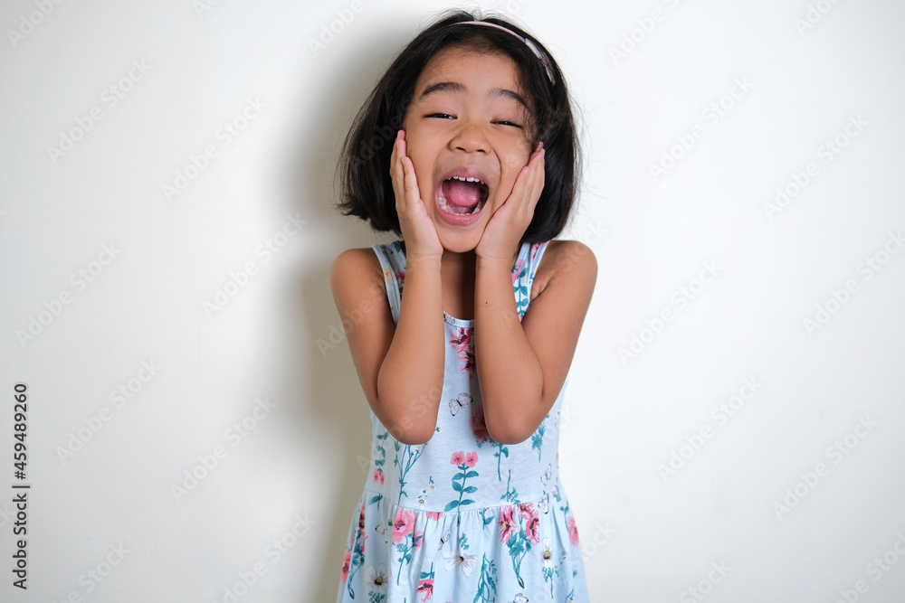 Asian little girl screaming excited while her hand touching cheek Asian little girl screaming excited while her hand touching cheek