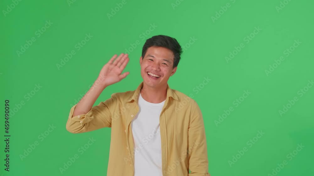 The Happy Young Asian Man Waving Hand While Standing On Green Screen In The Studio
The Happy Young Asian Man Waving Hand While Standing On Green Screen In The Studio