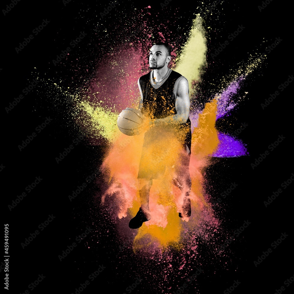Fototapeta premium High jumping. Young man, a male basketball player in explosion of colored powder