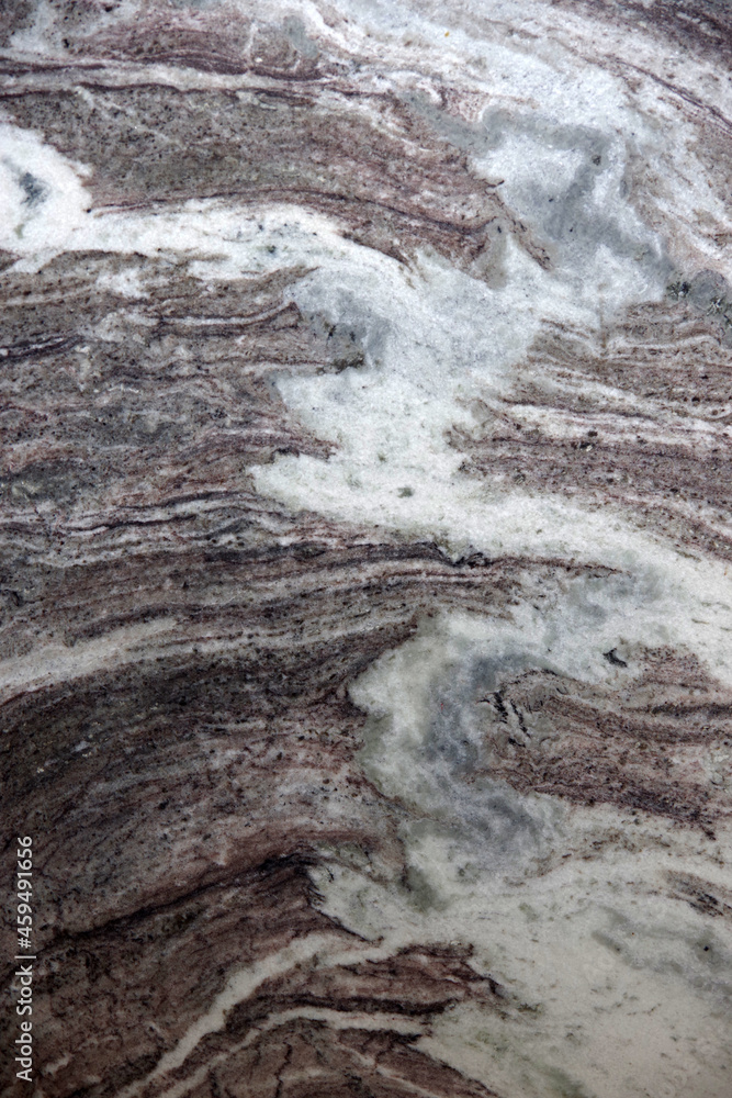 Fototapeta premium Full frame close-up view of a brown and white marbled granite stone surface with a variety of patterns