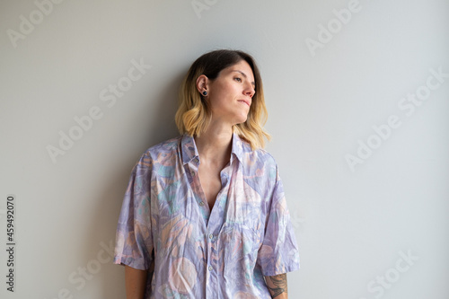 Beautiful young blonde girl with tattoos and colorful shirt with copyspace