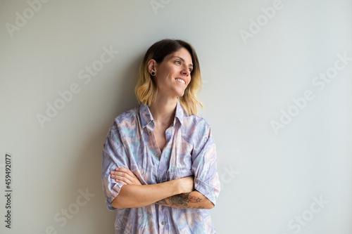 Beautiful young blonde girl with tattoos and colorful shirt with copyspace