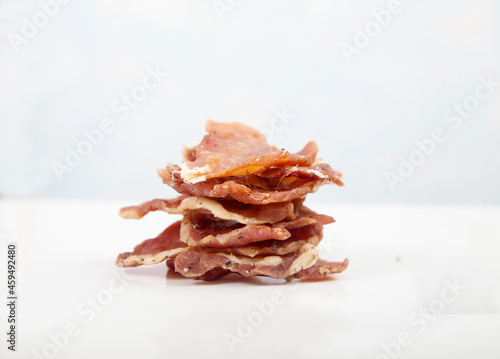 Pieces of jerky are stacked on a white background. Isolate.