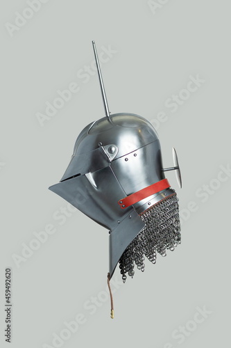 Medieval knightly Milanese helmet with a heraldic kleinod in the form of a swan and a crown, period of the 15th century, on a light background. photo