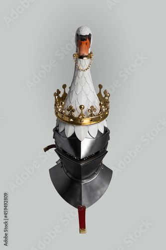 Medieval knightly Milanese helmet with a heraldic kleinod in the form of a swan and a crown, period of the 15th century, on a light background. photo