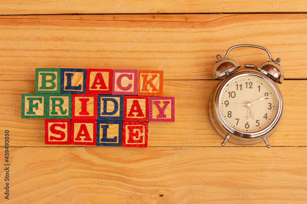 SPECTACULAR CONCEPT OF BLACK FRIDAY AND SALES WITH WOODEN CUBES AND WITH WOODEN SURFACE WITH OLD ALARM CLOCK. SPECTACULAR CONCEPT OF BLACK FRIDAY AND SALES WITH WOODEN CUBES AND WITH WOODEN SURFACE WITH OLD ALARM CLOCK.