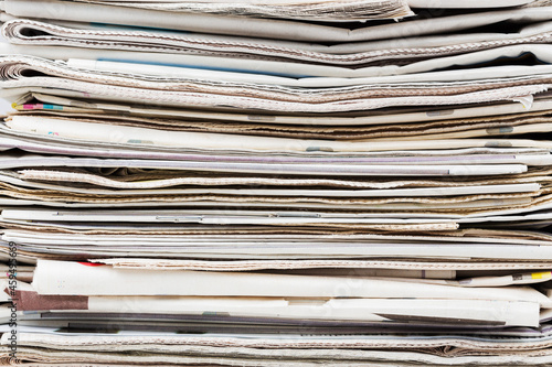 Pile of stacked generic folded newspapers background