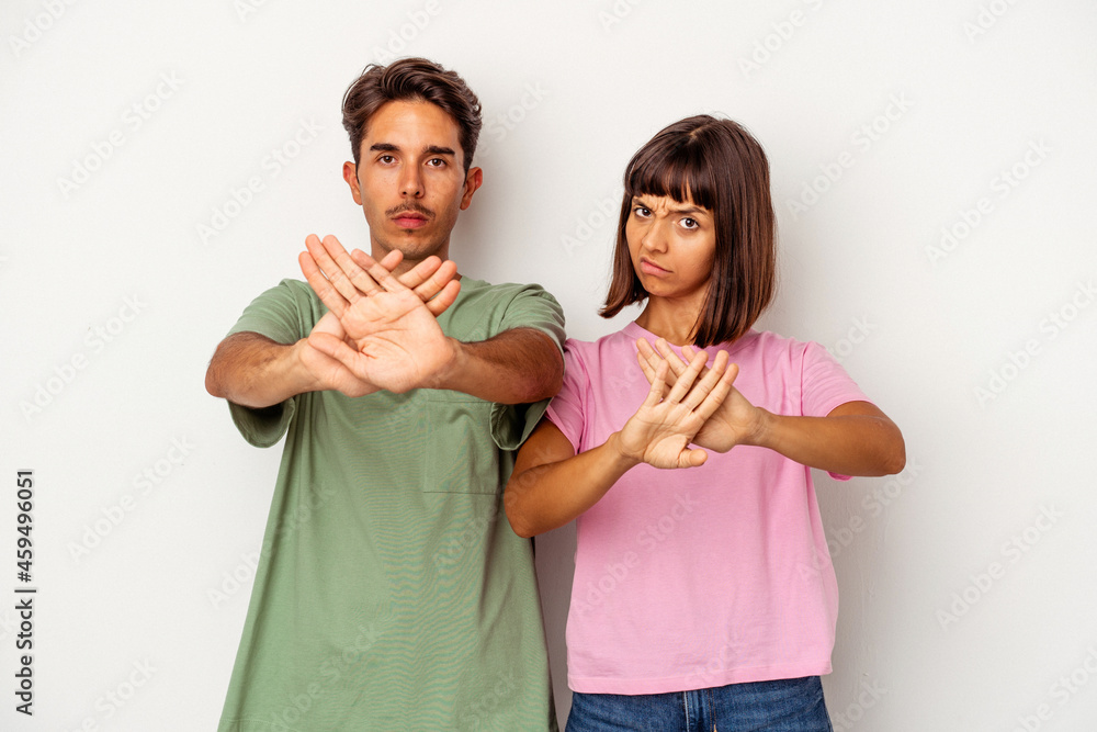 Young mixed race couple isolated on white background standing with outstretched hand showing stop sign, preventing you. Young mixed race couple isolated on white background standing with outstretched hand showing stop sign, preventing you.