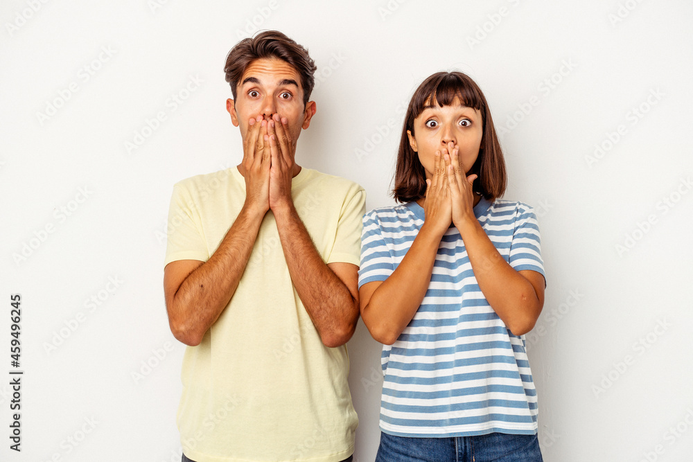 Young mixed race couple isolated on white background shocked covering mouth with hands. Young mixed race couple isolated on white background shocked covering mouth with hands.