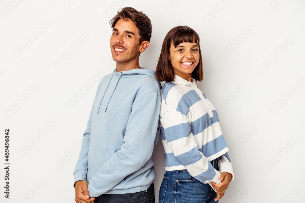 Young mixed race couple isolated on white background confident keeping hands on hips. Young mixed race couple isolated on white background confident keeping hands on hips.