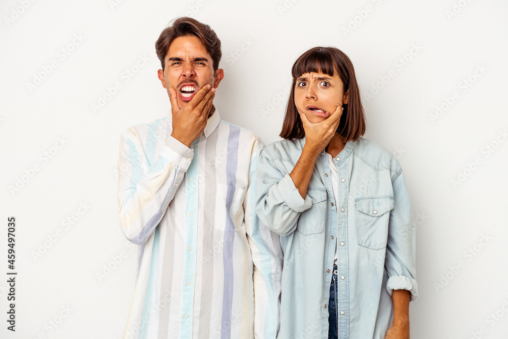Young mixed race couple isolated on white background having a strong teeth pain, molar ache. Young mixed race couple isolated on white background having a strong teeth pain, molar ache.