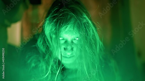 Scary ghost woman screaming through dirty glass on dark background. Monster devil or female spirit dead characters.
