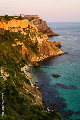 Beautiful rocky seashore during the evening sunset. Vertical evening landscape