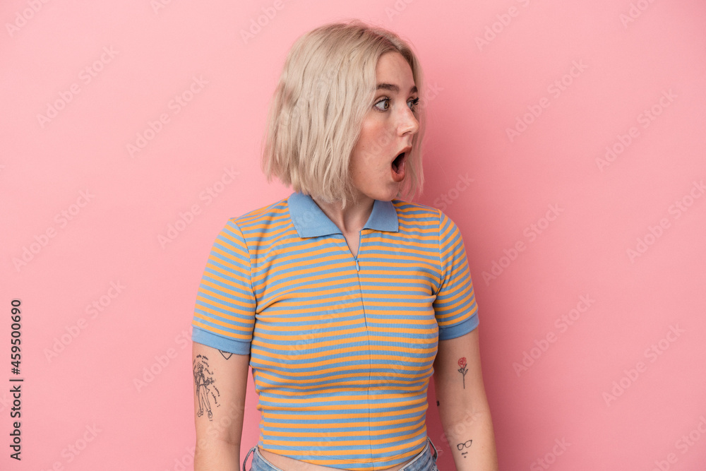 Young caucasian woman isolated on pink background being shocked because of something she has seen. Young caucasian woman isolated on pink background being shocked because of something she has seen.