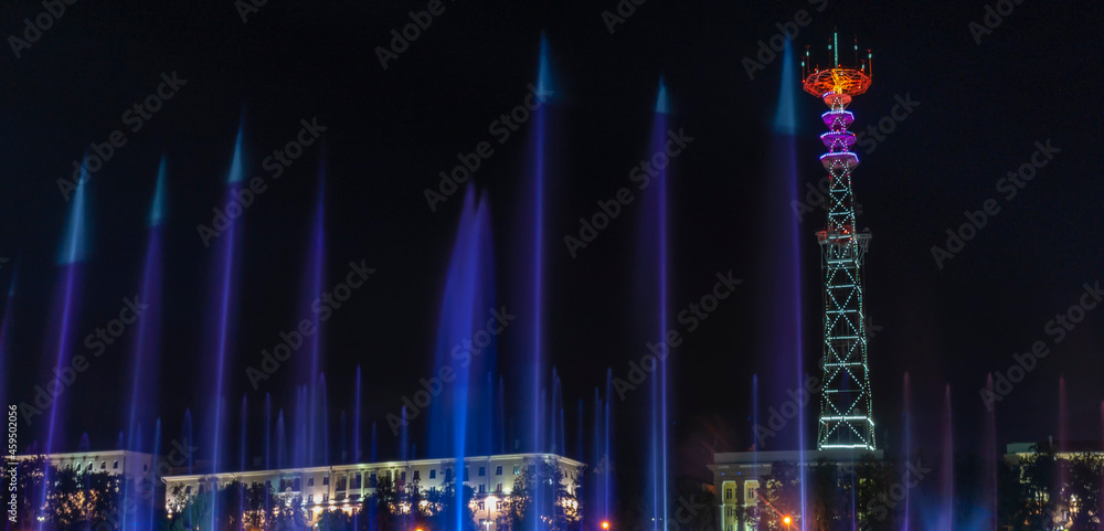 TV Tower in festival illumination. On foreground fountain with long exposure water drop. Festive concept.
