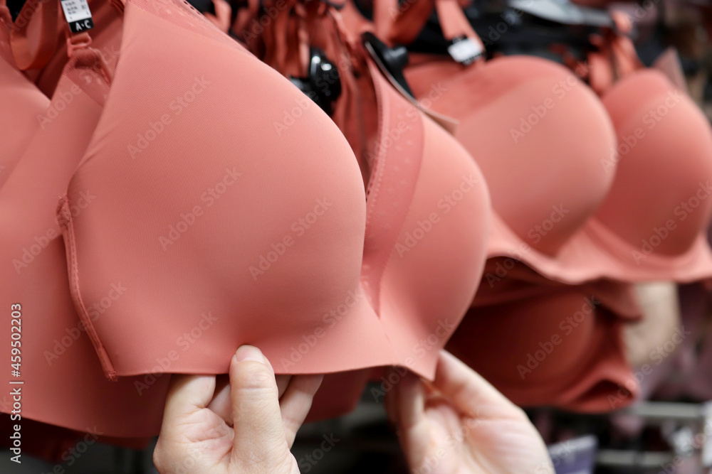 © Oleg - Seamless bra hanging on rack in lingerie store. Woman chooses sexy underwear © Oleg - Seamless bra hanging on rack in lingerie store. Woman chooses sexy underwear